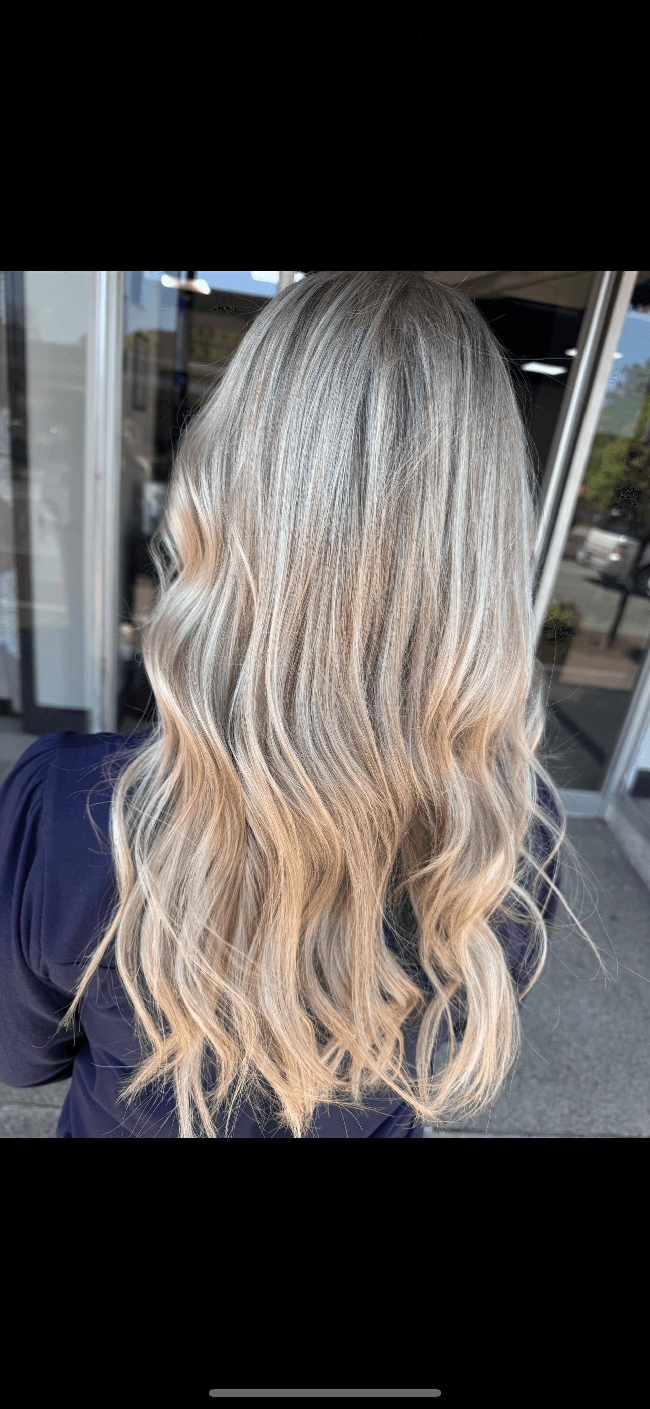 Butter blonde balayage with long beach waves and a seamless blend, worn by a client of Brooke Holland.